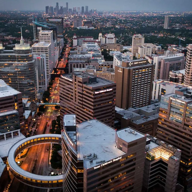 Downtown cityscape during dusk with illuminated streets.