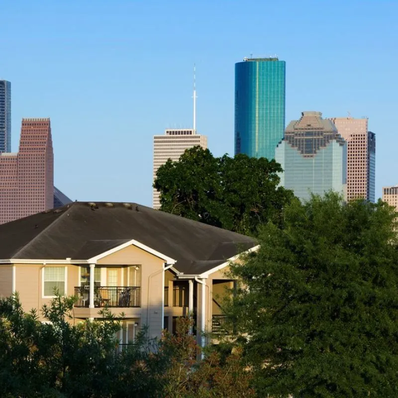 Suburban house foreground with city skyline background.