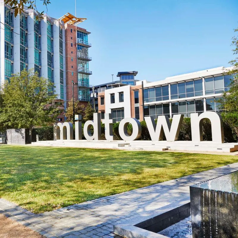 Midtown sign with greenery in urban park setting