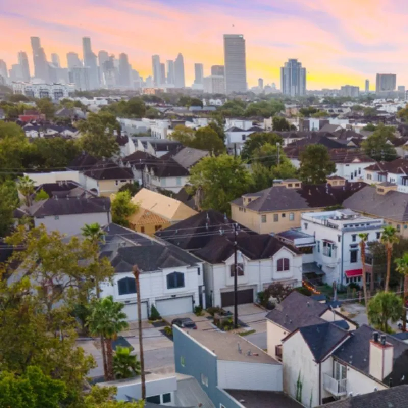 Sunset over urban skyline with residential homes.